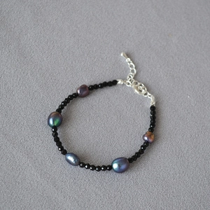 Collana elegante con grani di spinello nero e cinque perle scure dai riflessi cangianti