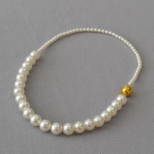 Dettaglio della collana di perle eleganti di varie dimensioni con chiusura magnetica dorata