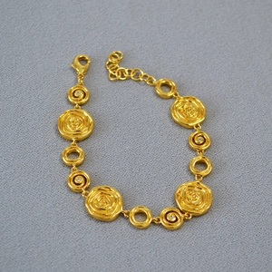 Close-up of vintage gold-plated rose bracelet with irregular texture and crystal accents