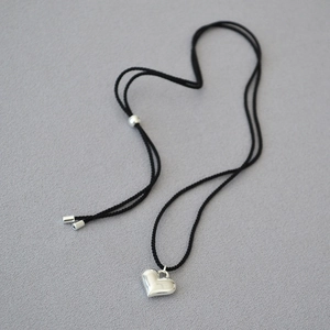 Minimalist adjustable black cord necklace with a polished silver heart pendant for women