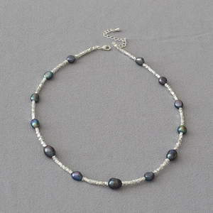 Detailed view of Tahiti style black pearls and irregular silver beads with lobster clasp