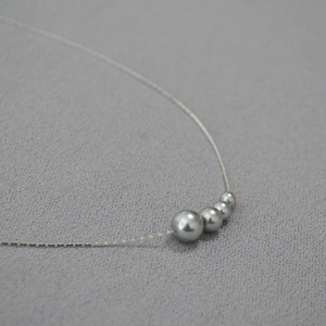 Détail macro de perles dégradées minimalistes sur un collier en fil plaqué or fin