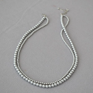 Detail of silver grey double-layer faux pearl necklace with adjustable metal chain