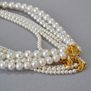Detailed close-up of mixed round pearl necklaces with elegant gold figure-8 clasps