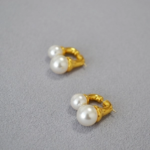 Chic double pearl gold hoop earrings with polished metal finish on textured background