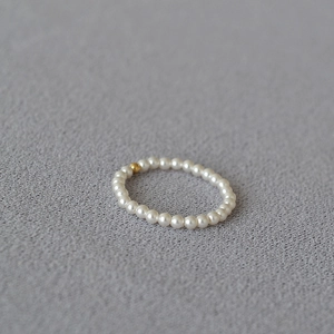 Detailed view of a handmade 14K gold-filled bead and lustrous pearl minimalist beaded ring