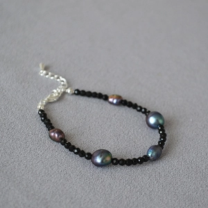 Dettaglio di perle di spinello nero sfaccettate e perle di Tahiti con riflessi cangianti