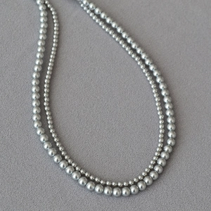 Detail of elegant gray double-layer faux pearl necklace with metallic high-gloss finish