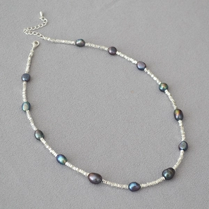 Macro detail of dark Tahitian style pearls and silver faceted beads with lobster clasp
