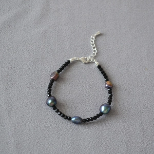 Dettaglio di perle di spinello nero e perle iridescenti scure con chiusura in argento