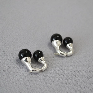 Detailed view of silver hoop earrings featuring asymmetrical black onyx double beads