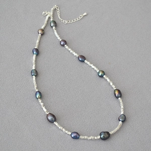 Macro detail of dark Tahitian pearls with silver faceted beads and adjustable clasp