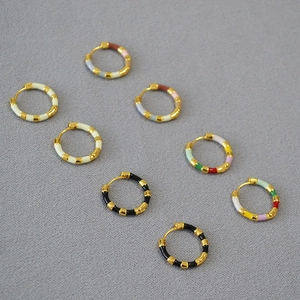 Detailed view of colorful enamel brass hoop earrings in multiple stylish finishes
