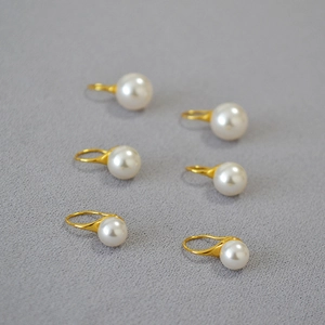 Gros plan de boucles d'oreilles perles rondes avec crochets dorés minimalistes lot de six