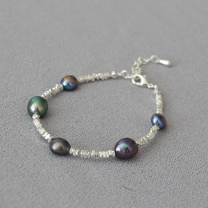 Macro shot of dark baroque pearls and irregular silver beads on a short necklace