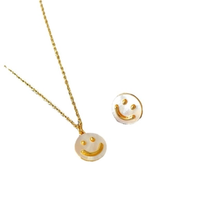 Set minimalista placcato oro con collana e orecchini con faccina sorridente in conchiglia