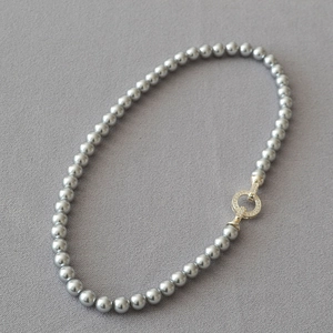 Lustrous dark grey pearl necklace with a gold micro-pave zirconia circular clasp