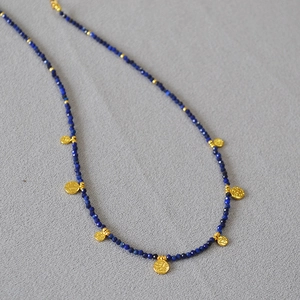 Détail du collier de perles en lapis-lazuli avec des pendentifs en pièces dorées vintage
