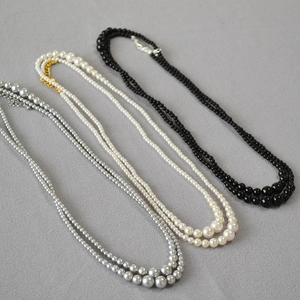 Detailed close-up of double-layer gradient pearl necklaces in black, white and grey colors