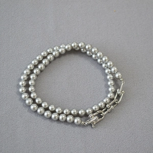 Détail du collier de perles grises avec fermoir métallique moderne en U argenté