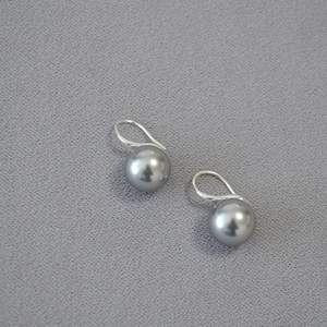 Close-up of elegant grey round pearls on minimalist S925 silver hook earrings