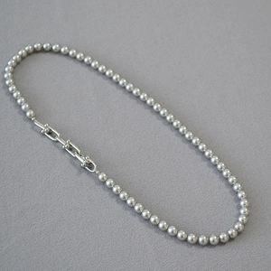 Collier de perles argentées avec fermoir à maillons en U élégant sur tissu gris clair