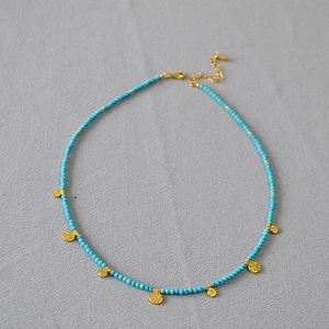 Collier bohème en perles turquoise avec pendentifs pièces dorées et fermoir ajustable