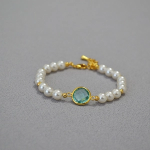 Elegant pearl bracelet with faceted sea blue crystal and golden metallic accents