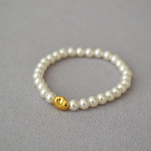 Baroque style elastic bracelet with cream white pearls and a gold irregular metal bead