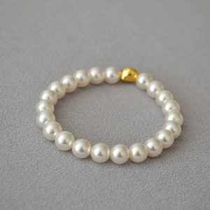 Close-up of elegant baroque pearl bracelet featuring a single polished gold bead accent