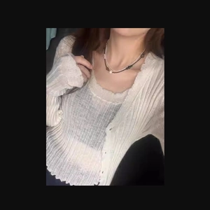 Close-up of white ribbed knit cardigan set with matching camisole for women