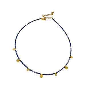 Collier en perles de lapis avec sept pendentifs pièces dorées martelées et fermoir homard
