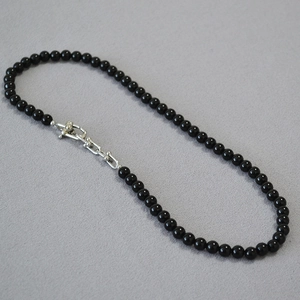 Detail of black onyx bead necklace with polished silver U-link chain closure mechanism
