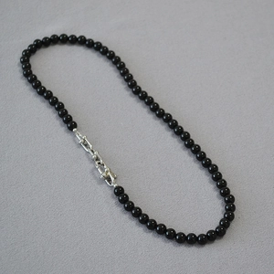 Close-up of black agate beaded necklace with silver U-link chain hardware detail