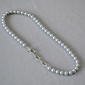Détails des perles gris argenté et des maillons en U sur le collier de style moderne