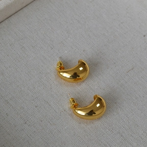 Detailed view of teardrop gold-plated brass stud earrings with a polished mirror finish