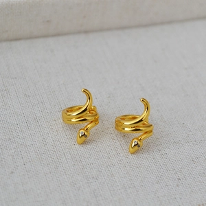 Detailed view of gold plated brass snake hoop earrings with sparkling cubic zirconia eyes