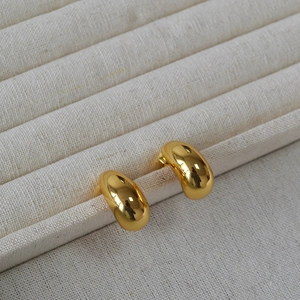 Polished chunky gold teardrop earrings made of gold-plated brass on a linen jewelry box