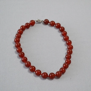 Macro detail of red carnelian beads and silver clasp on the vintage necklace