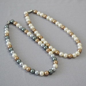 Detail of multi-color pearl necklace with white, champagne and grey pearls and silver clasp