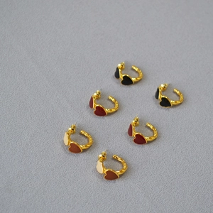 Detailed view of handmade vintage enamel heart earrings with unique hammered gold texture