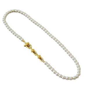 Collier de perles élégant avec des accents de chaîne à maillons U dorés polis sur fond blanc