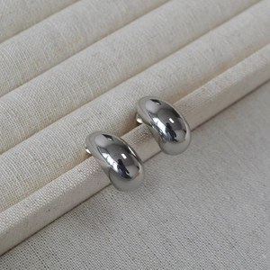 Minimalist silver teardrop stud earrings with a polished mirror finish in a display box