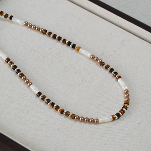 Gros plan détaillé de la texture du collier de perles faites à la main en oeil de tigre