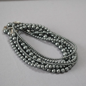 Detail of multilayer grey imitation pearl necklace with vintage silver toggle clasp
