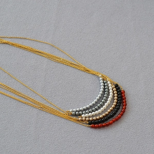 Detail view of five minimalist necklaces with colorful agate beads and gold fine chains