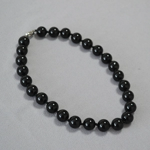 Detail of polished black agate beads necklace with secure silver lobster clasp closure