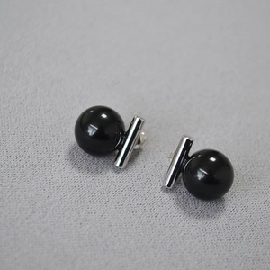 Détail macro de boucles d'oreilles barre avec perles d'onyx noires et tiges en argent