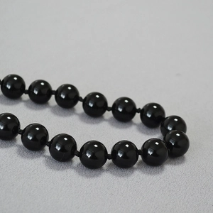 Macro shot of handcrafted black agate beads with professional knots for jewelry durability
