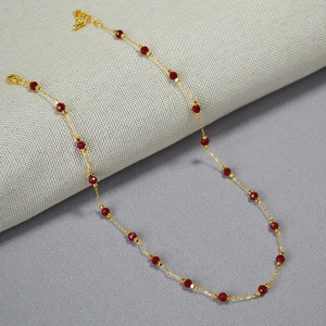 Minimalist brass gold-plated necklace with red faceted cinnabar beads in elegant red-gold